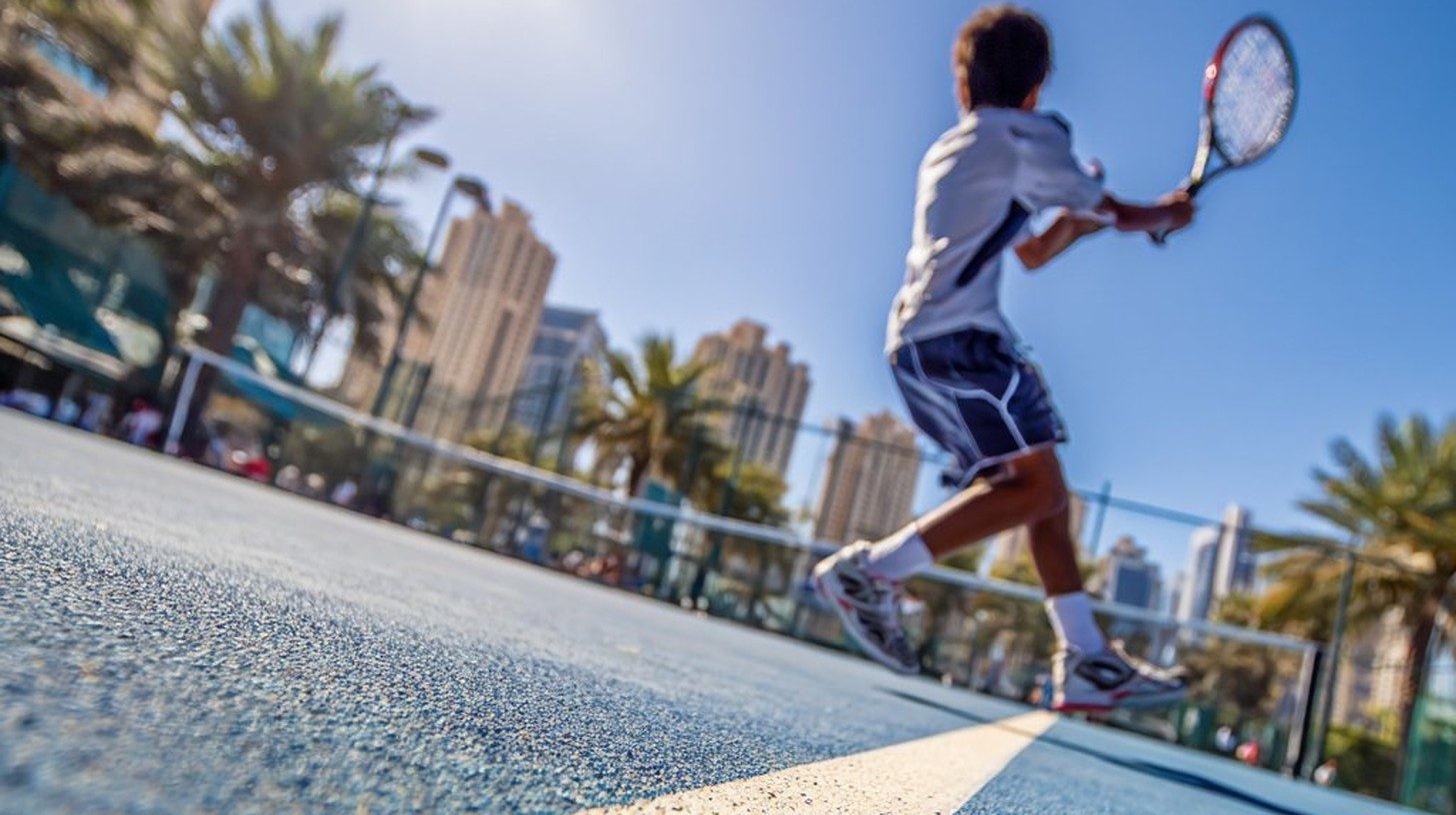 Junior tennis player on court at a UAE tennis academy
